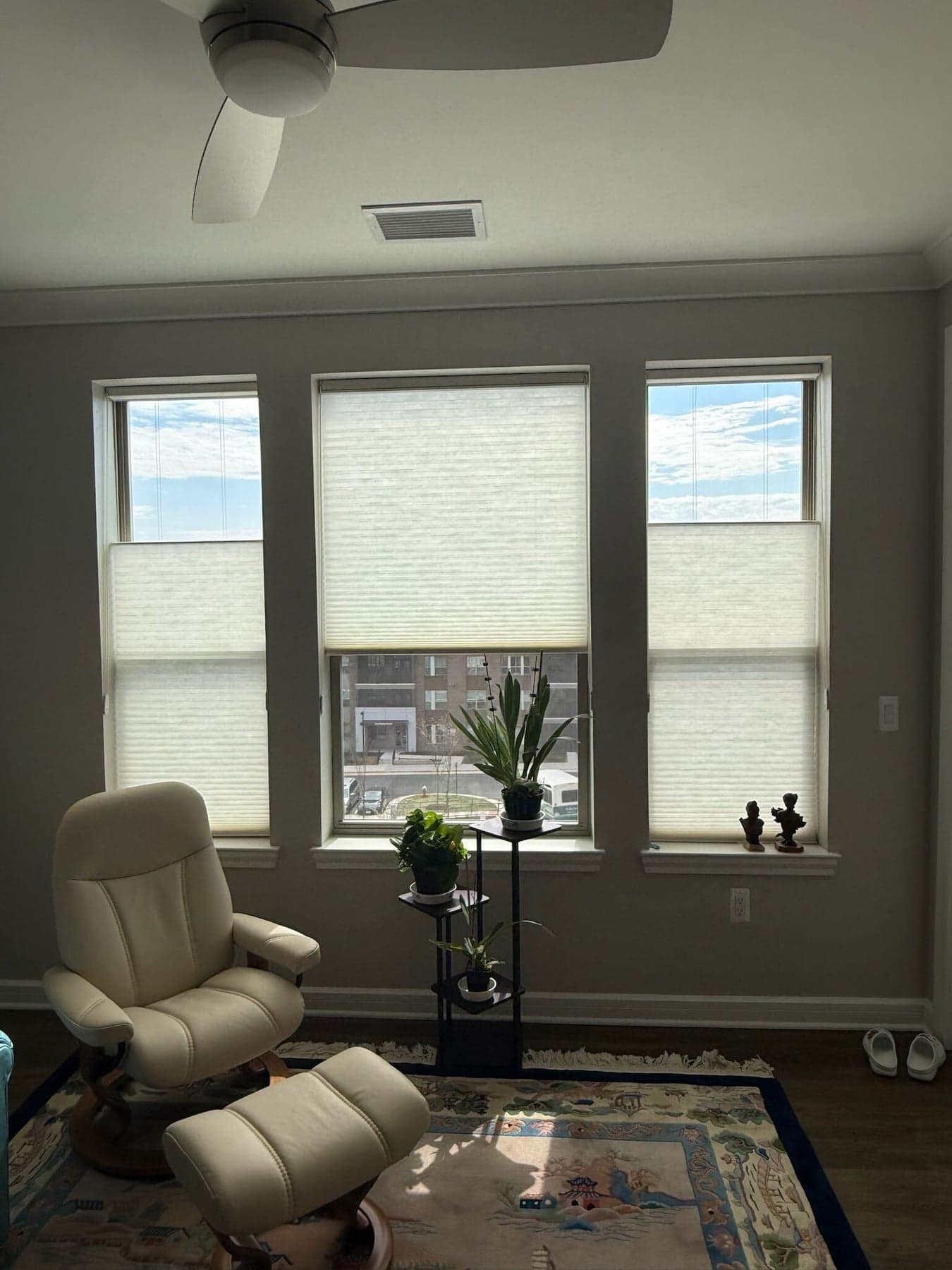 Three living room windows with light-filtering shades lowered from the top